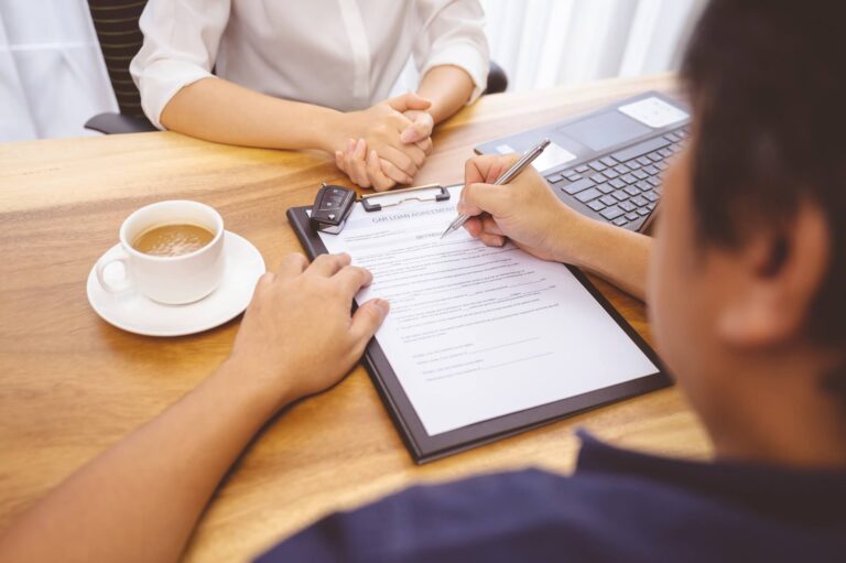 A man signing a car loan agreement