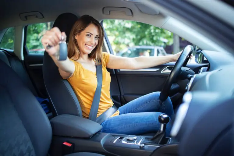 A woman sitting in the driver's seat holding the car keys