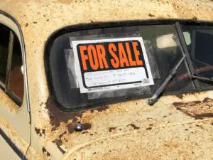 A "for sale" sign on an old vehicle
