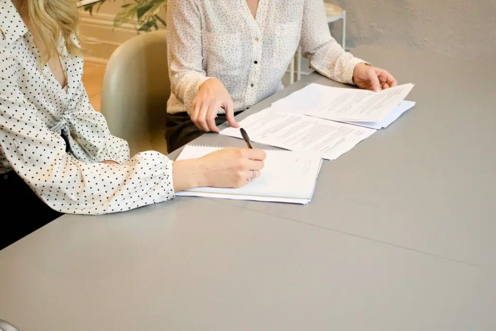 Two women going over contracts after negotiating