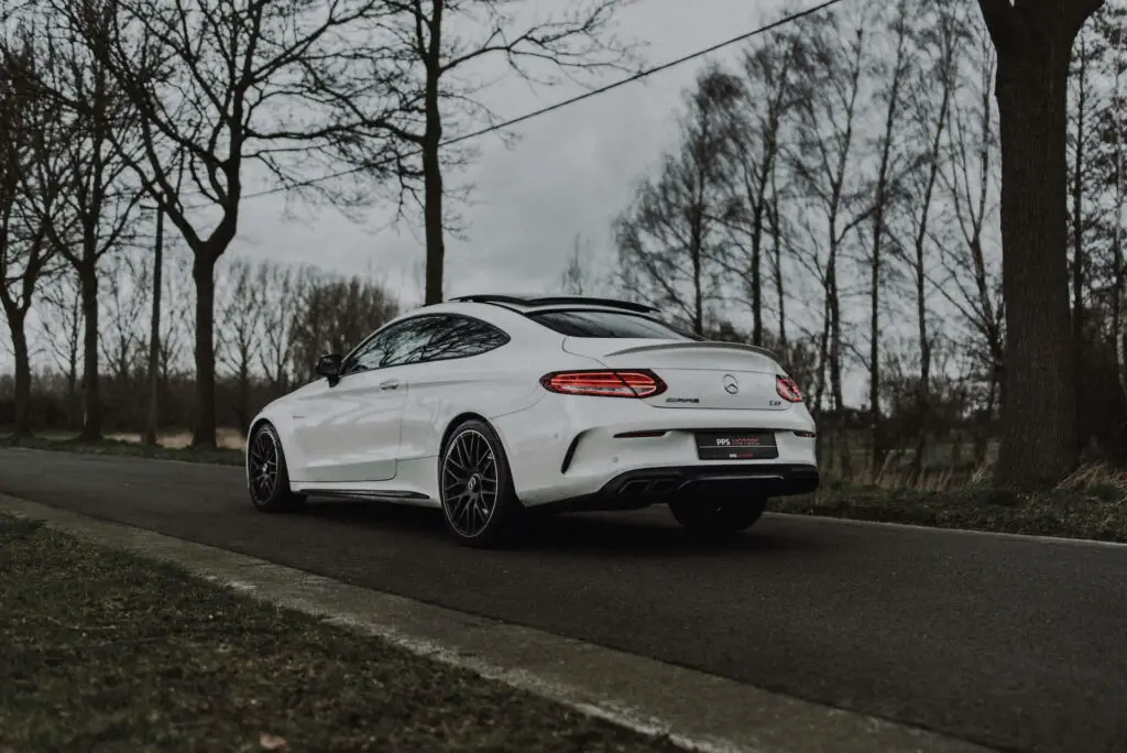 A white Mercedes C63 on an empty road