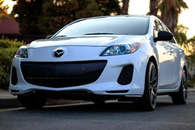 White Mazda parked on the side of the road