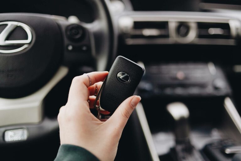 A person holding a Lexus car key